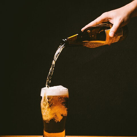 beer being poured in a glass